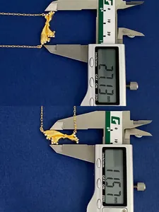 Detailed measurement of the gold bow pendant size with digital caliper on blue fabric