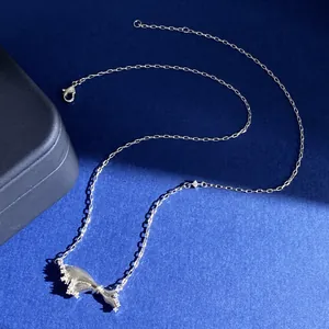 Detail shot of bow-shaped pendant with sparkling crystals and fine silver link chain