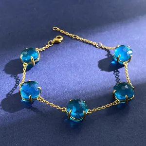 Detail of five blue faceted stones on a gold chain with lobster clasp and extender