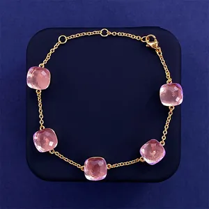 Close-up of five square pink crystal stones on a delicate gold-plated adjustable chain