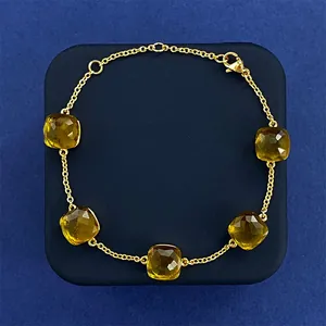 Minimalist gold chain bracelet featuring five cushion-cut yellow crystal gemstones