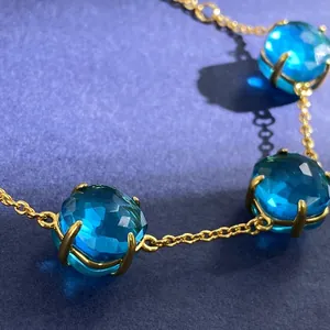 Japanese gold necklace featuring three faceted blue crystals with elegant four-prong setting
