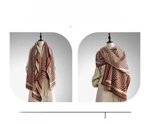 Detail of cashmere-like shawl scarf with geometric pattern in brown and beige colors