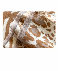 Detalle de bufanda de leopardo con flecos finos retorcidos y textura suave de cachemira
