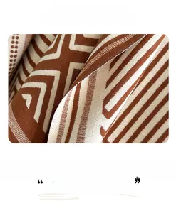 Macro detail of geometric cashmere-feel fabric with herringbone pattern and fringe edges