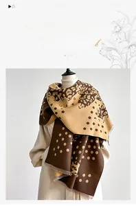 Detail of leopard print winter scarf with tassels showing thick faux cashmere texture