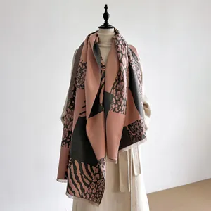 Detalle de bufanda con estampado de leopardo rosa y gris, con flecos y textura de punto