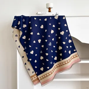 Detailansicht des dunkelblauen Herzmuster-Schals mit beigen Fransen und weicher Stricktextur