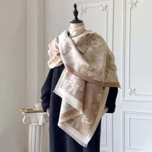 Detailed view of elephant and paisley jacquard pattern with fringe on cashmere-like shawl