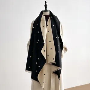 Detail van dubbelzijdige gebreide sjaal met hartjespatroon en franjes op een mannequin