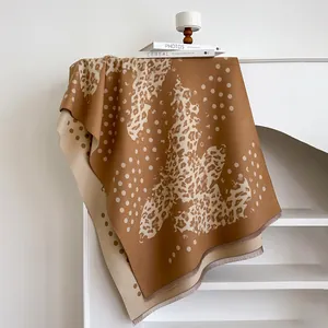 Close-up of thick leopard print scarf with double-sided pattern and delicate fringe details