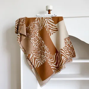 Vista detallada de la bufanda tipo patchwork con estampado de leopardo y flecos