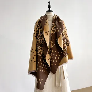 Detail of thick winter shawl featuring leopard print, dots, and fringe edges
