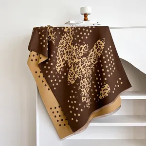 Detailed close-up of a thick leopard print scarf with soft fringe and polka dot pattern