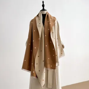 Detail van karamel en beige kasjmier sjaal met hartjes jacquard en franje randen