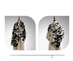 Dettaglio scialle a pois geometrici bianco e nero con bordo a frange morbide
