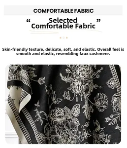 Detail of soft cashmere-like fabric scarf featuring floral patterns and houndstooth edge