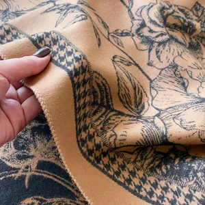 Close-up of floral cashmere feel scarf showing thick jacquard texture and finished edge