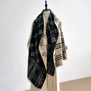 Detailed view of bicolor checkered cashmere-feel scarf with clover patterns and fringe