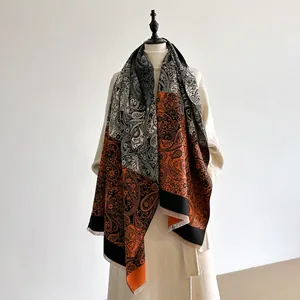 Detail of vintage paisley pattern cashmere-feel scarf with orange and black floral tassels