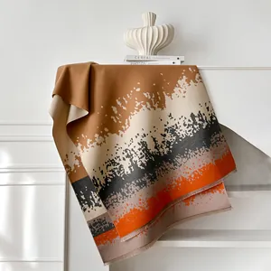 Artistic abstract print winter scarf with tassels displayed on a minimal white table