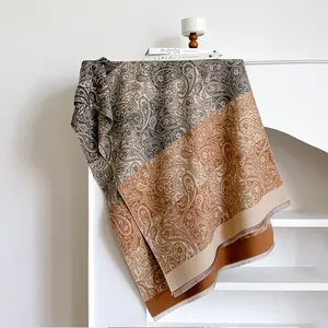 Close-up of paisley pattern and soft fringe tassels on a luxury cashmere-feel scarf