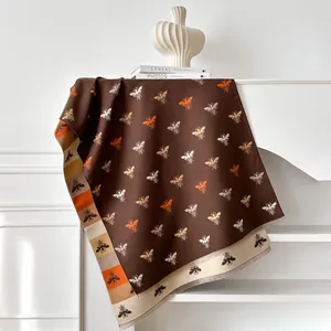 Close-up of double-sided bee pattern scarf with fringe and soft cashmere-like texture