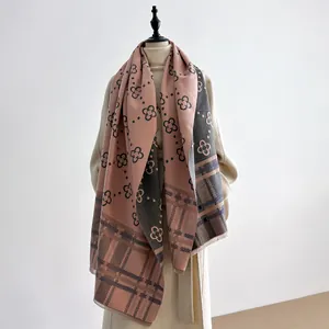Detail view of pink and grey cashmere-like scarf with floral prints and classic plaid patterns