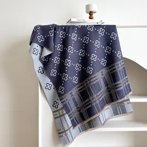 Detail of navy and grey scarf featuring clover patterns, check weave, and fine tassels