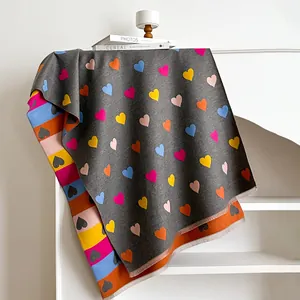 Macro detail of thick heart-patterned shawl with colorful stripes and tassel edges