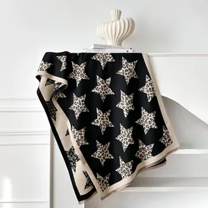 Dettaglio della sciarpa in maglia con stelle leopardate e morbida trama in cashmere