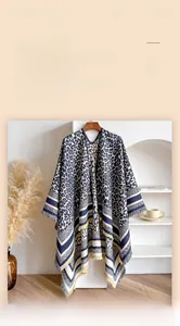 Close-up of soft leopard print cashmere shawl with striped borders and fringe details