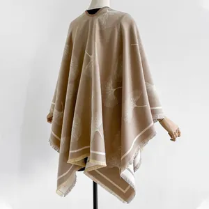 Détail d'un châle en maille douce avec motif de feuilles de ginkgo et franges délicates
