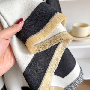 Detail eines weichen gestreiften Strickschals mit Quasten und warmer Textur