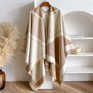 Detailed close-up of geometric V-pattern pashmina shawl with fringe trim on wooden hanger