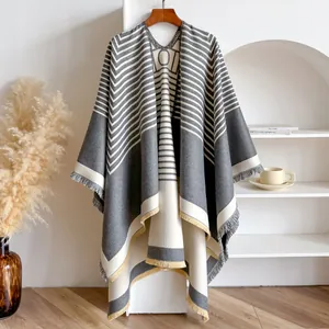 Details des grau-weißen geometrischen Ponchos mit Quasten und Fransen-Textur