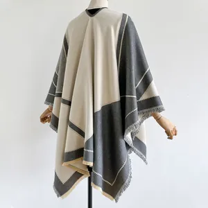 Detailed view of color-blocked shawl wrap with elegant fringe edges and soft texture