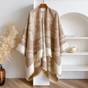 Détails de motifs floraux et de franges sur un châle en cachemire tricoté camel