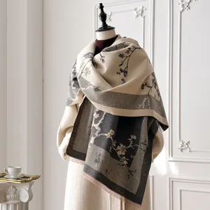 Thick beige and grey floral cashmere-feel scarf with tassels on a mannequin