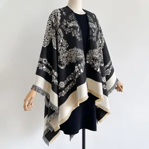 Détail d'un châle vintage à imprimé floral noir et blanc avec des franges élégantes