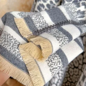 Close-up of leopard pattern cashmere scarf with delicate tassels and stripe details