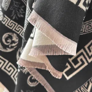 Close-up of thick cashmere-feel scarf with Greek key patterns and elegant fringe details