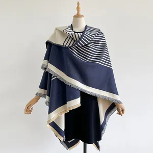 Detailaufnahme von marineblau-beigem Strick-Poncho mit eleganten Fransen am Saum für Damen