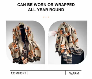 Detail of floral shawl showing soft fabric texture and fine fringe edge in beige and orange