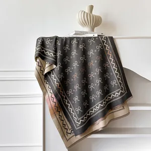 Detailansicht des Jacquard-Musters mit Schleifen und ausgefransten Fransen am Schal