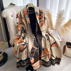 Close-up of floral shawl with orange and black leaves, tassels, and double-sided texture