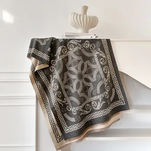 Macro detail of dark grey cashmere scarf featuring Greek key borders and baroque patterns