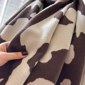 Vue détaillée d'une écharpe douce en imitation cachemire avec motif tricoté vache