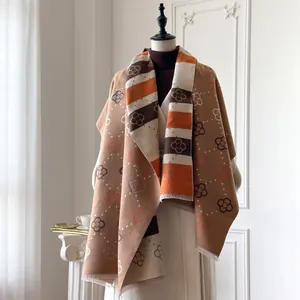 Detailweergave van een lange winter sjaal met oranje en bruine bloemmotieven