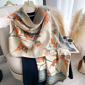 Detailed view of elegant floral pattern and fringe edge on a beige winter shawl wrap